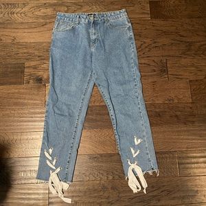 Jeans with distressed lace up ribbon bottoms